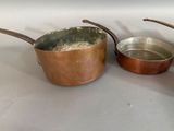 two pots and pans sitting on a table