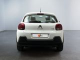 the rear of a white car with a black tail light on
