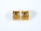 une paire de boucles d'oreilles en or sur fond blanc