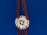 a person holding a necklace with beads hanging from it