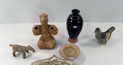 une table blanche sur laquelle sont disposées différentes sortes de poteries