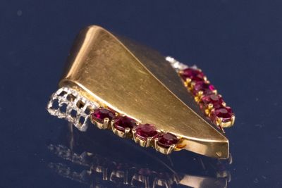 une broche en or ornée de pierres rouges et blanches