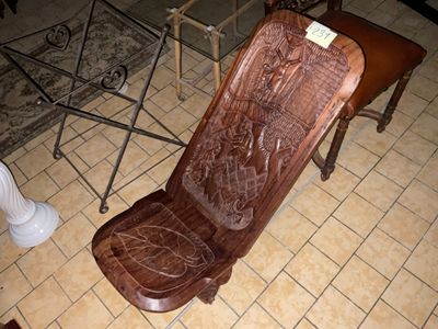 une chaise en bois posée sur un sol carrelé