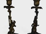 paire de bougeoirs anciens en laiton reposant sur des socles en marbre noir