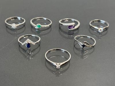 several different rings are arranged in a row on a table