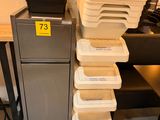 Dans un magasin, plusieurs plateaux de nourriture sont empilés les uns sur les autres