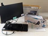 un écran d'ordinateur, un clavier, une souris et d'autres objets posés sur la table