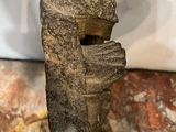 a close up of a sculpture of a person holding a piece of wood