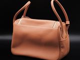 a tan leather handbag sitting on top of a black surface