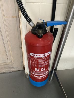 a fire extinguisor sitting on the floor next to a door