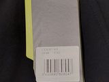 the back of a black jacket with a yellow tag attached to it