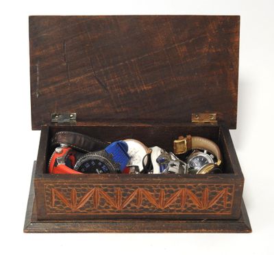 a wooden box filled with assorted items on a white surface