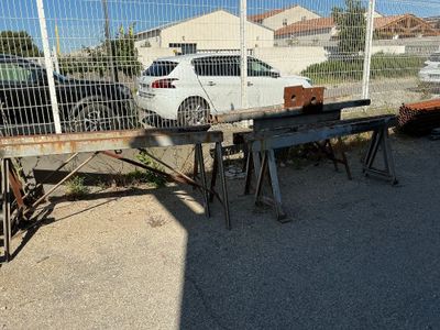 une voiture blanche garée derrière une clôture dans un parking