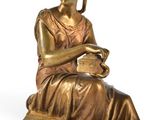 bronze statue of a woman sitting on a stool holding a teapot