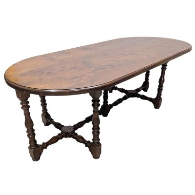 an oval dining table with turned legs and a wooden top