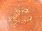 a red plate with a picture of a bird and a fish on it