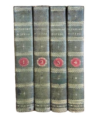 trois vieux livres posés l'un sur l'autre sur une surface blanche