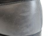 a close up of a pair of black shoes on a white surface