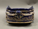 a blue and gold planter with a lion head on it
