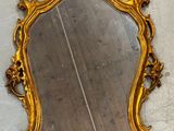 un miroir posé au sol, avec un cadre doré