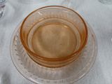 a glass plate with a bowl on it on a table