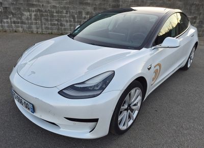 La Tesla Model 3 blanche est garée sur un parking