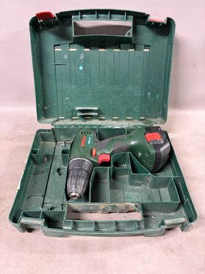 une boîte à outils verte contenant une perceuse et un foret