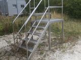 a metal stair going up to the top of a hill