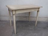 a small table with a wooden top on a cement floor
