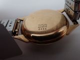 a close up of a watch on a table with a keyboard
