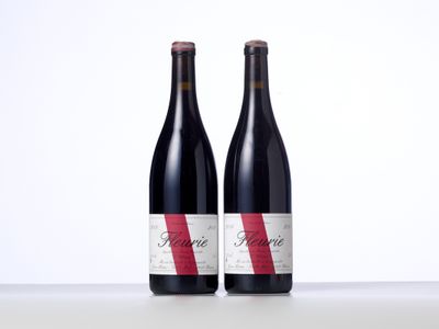 two bottles of red wine sitting next to each other on a table