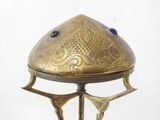 a gold plate with a blue stone on top of it