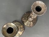 pair of antique silver candlesticks on a grey background