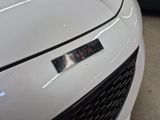 a close up of a white car with a clock on the hood