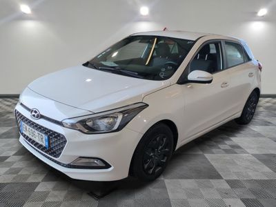 la voiture blanche est garée sur le sol à carreaux d'un garage
