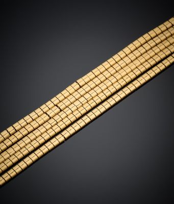 gros plan d'un bracelet en or sur fond noir