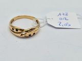 gros plan d'une bague en or sur une surface blanche avec une étiquette de prix