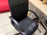 a black office chair sitting in front of a computer desk