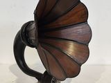 un vieux gramophone posé sur un support, sur une surface blanche
