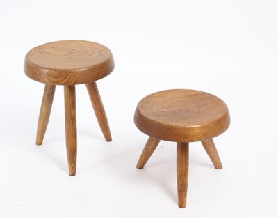 two small wooden stools sitting next to each other on a white surface