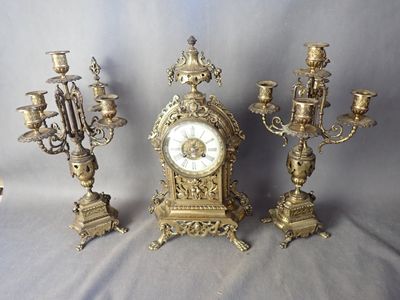 plusieurs types différents d'horloges anciennes et de lustres posés sur une table