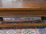 a wooden table with a wooden top on a rug