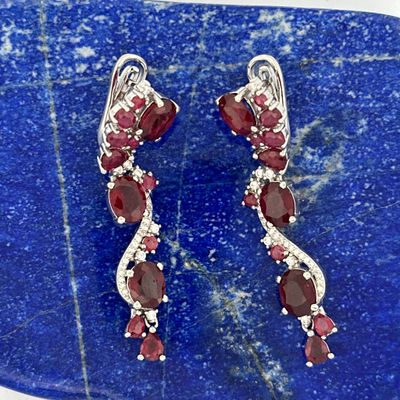 pair of garnet and diamond earrings on a blue stone slab