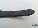 a close up of a black leather watch strap on a white surface