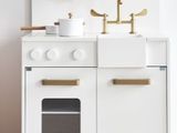 a white kitchen with a white stove and white cabinets