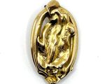 a gold pendant with a horse on it on a white surface