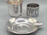 two silver cups and a silver saucer on a table
