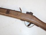 an old wooden rifle laying on top of a white table
