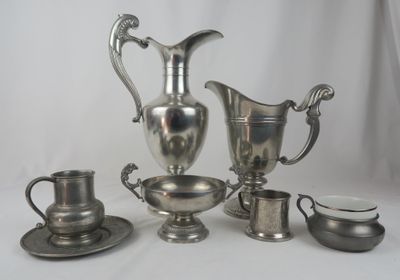 un service à thé en argent avec des tasses et des soucoupes posé sur une table