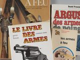 trois livres posés sur une table, avec un pistolet posé dessus